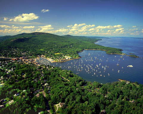 Mountains meet the ocean in Camden, Maine - Acadia Center is in the foreground, aerial photo by Ben Magro.